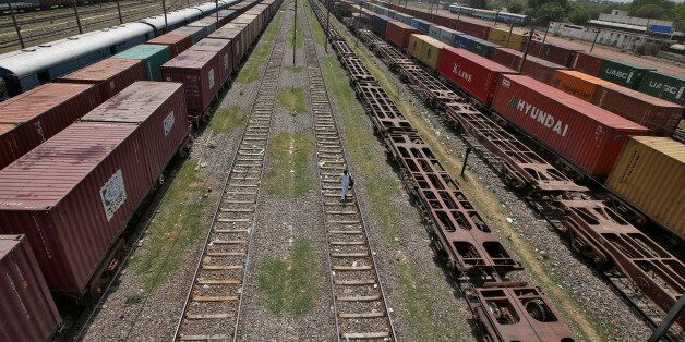 A man walks on a railway track as freight trains are parked at Tughlakabad railway station in New Delhi, India, April 20, 2017. Picture taken April 20, 2017. REUTERS/Adnan Abidi
