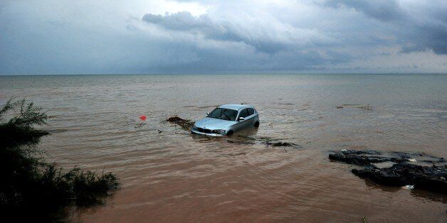 TOPSHOT - A car washed away into the sea is pictured following floods caused by heavy overnight rain, on 7 September, 2016 in Agia Triada, a suburb of Thessaloniki. / AFP PHOTO / Sakis Mitrolidis (Photo credit should read SAKIS MITROLIDIS/AFP/Getty Images)