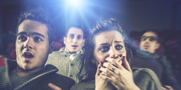 Couple scared at the cinema, watching horror movie