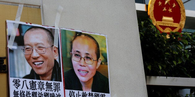 Photos of Chinese Nobel rights activist Liu Xiaobo (L) and wife Liu Xia are left by protesters outside China's Liaison Office in Hong Kong, China June 27, 2017. REUTERS/Bobby Yip