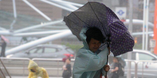 A woman uses an umbrella against strong wind and rain brought by typhoon Dujuan at Tamshui district, New Taipei City on September 28, 2015. More than 7,000 people were evacuated in Taiwan as 'super typhoon' Dujuan swirled towards the island, gathering strength as it bore down on the east coast. AFP PHOTO / Sam Yeh (Photo credit should read SAM YEH/AFP/Getty Images)