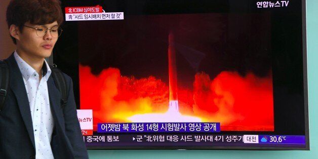 A man walks past a television screen showing a video footage of North Korean leader Kim Jong-Un celebrating his country's latest test launch of an intercontinental ballistic missile (ICBM), at a railway station in Seoul on July 29, 2017.North Korean leader Kim Jong-Un said on July 29 the country's second ICBM test demonstrated the ability to strike any target in the United States, in a direct challenge to President Donald Trump who had issued dire warnings over its missile program. / AFP PHOTO / JUNG Yeon-Je (Photo credit should read JUNG YEON-JE/AFP/Getty Images)