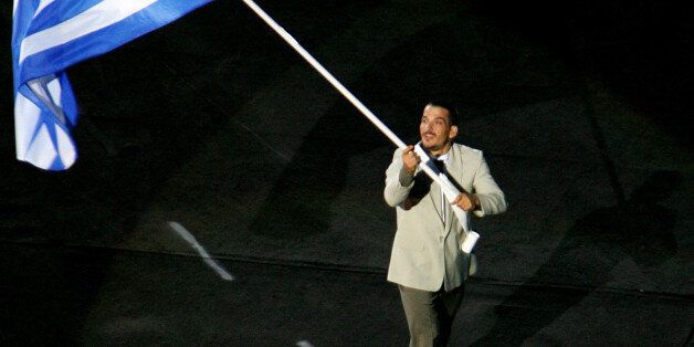 The Greek flag, carried by Piros Dimas, is the first to enter the Olympic Stadium during the opening ceremony of the Athens 2004 Olympic Games August 13, 2004. A spectacular opening ceremony launched the Athens Olympics on Friday, lifting spirits in the Games' ancient birthplace. REUTERS/David Gray AW/AA