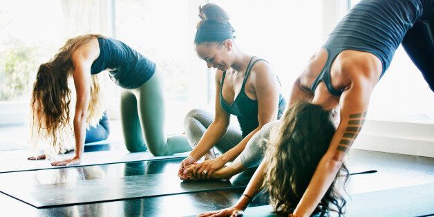 Group of women stretching before yoga class in studio