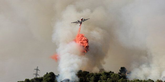 A firefighting plane drops flame retardant to extinguish a forest fire in Castagniers near Nice, France July 17, 2017. REUTERS/Eric Gaillard