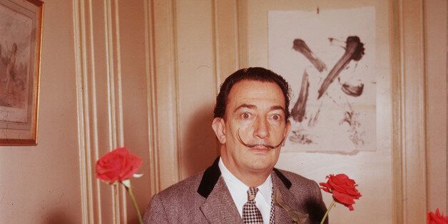 Surrealist Salvador Dali behind a spray of large red roses. France, ca. 1960s. (Photo by Paul Almasy/Corbis/VCG via Getty Images)