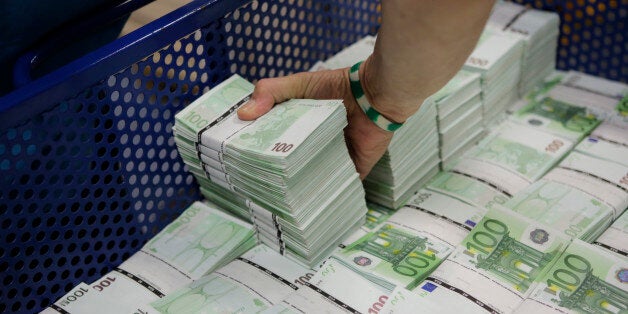 An employee of GSA Austria (Money Service Austria) stacks wads of new 100 euro banknotes at the company's headquarters in Vienna July 22, 2013. The GSA delivers new and collects old currency for the Austrian National Bank. REUTERS/Leonhard Foeger (AUSTRIA - Tags: POLITICS BUSINESS) BEST QUALITY IMAGE AVAILABLE