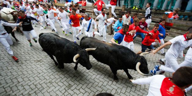 Pamplona, Spain - July 10, 2017: Bulls and people running on the street during the festival of San Fermin. Bulls of the cattle ranch of Fuente Ymbro in the fourth run of the festival of San Fermin