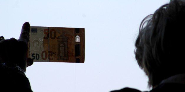 FRANKFURT, GERMANY - MARCH 16: A man holds and puts against daylight the new 50 Euro banknote, which will be start circulating to market on 4th April, during a press conference at Bundesbank's headquarters, with the participation of Carl-Ludwig Thiele (not seen), Member of the Executive Board of the Deutsche Bundesbank in Frankfurt, Germany on March 16, 2017. The new series of 50 banknotes takes its name from Europa, a figure from Greek mythology, whose portrait can be seen in both the watermark and the hologram of the new notes. Also this new note will have a portrait window which is visible on both sides when put against a light. (Photo by Abdulselam Durdak/Anadolu Agency/Getty Images)
