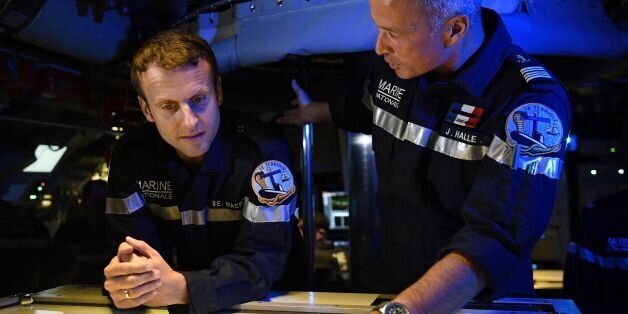 In this photograph taken at sea on July 4, 2017, French president Emmanuel Macron (L) listens as Captain Jerome Halle, commanding officer of the submarine 'Le Terrible' speaks in the operations centre of the vessel. / AFP PHOTO / POOL / Fred TANNEAU (Photo credit should read FRED TANNEAU/AFP/Getty Images)