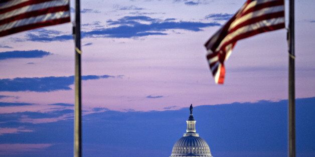 The U.S. Capitol building stands past American flags before sunrise in Washington, D.C., U.S., on Tuesday, July 11, 2017. As Congress returned from its mid-summer break yesterday for a crucial three-week stretch, several obstacles await lawmakers, including an ongoing health-care fight, divisions among Republicans on the basic parameters of a tax bill, and a maelstrom of upcoming deadlines to keep the government running and avert a catastrophic default on U.S. debt. Photographer: Andrew Harrer/B