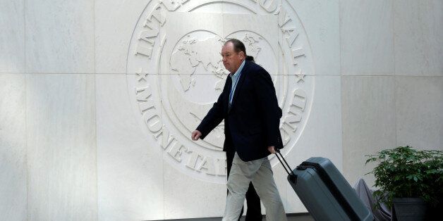A man walks past the International Monetary Fund logo during the IMF/World Bank spring meetings in Washington, U.S., April 21, 2017. REUTERS/Yuri Gripas