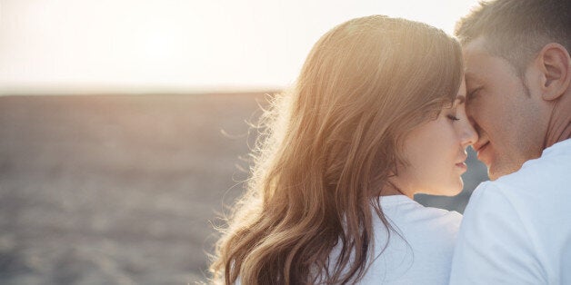 Two people embracing each other on the background of sea coast