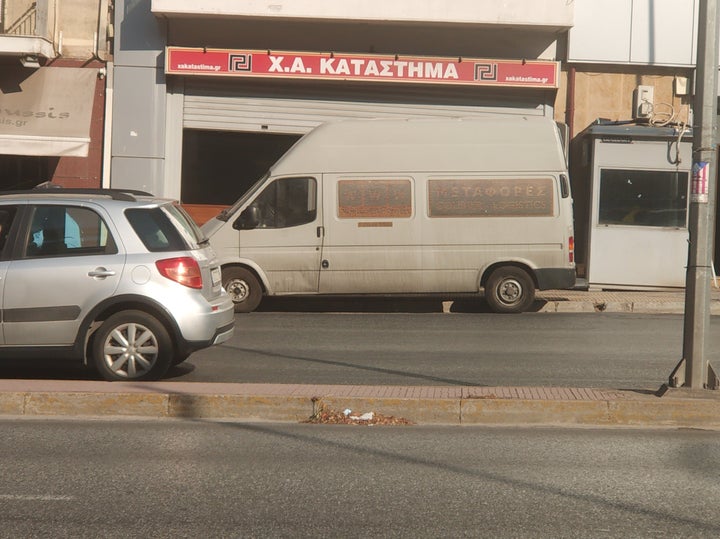 Φορτηγάκι βαν παραλαμβάνει ό,τι έχει απομείνει στο πολυόροφο κτήριο, που αποτελούσε την «Κεντρική Διοίκηση» του ακροδεξιού κόμματος.