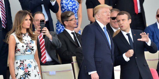 US President Donald Trump (C) speaks with French President Emmanuel Macron (R) as First Lady Melania Trump (2L) watches the annual Bastille Day military parade on the Champs-Elysees avenue in Paris on July 14, 2017.The parade on Paris's Champs-Elysees will commemorate the centenary of the US entering WWI and will feature horses, helicopters, planes and troops. / AFP PHOTO / CHRISTOPHE ARCHAMBAULT (Photo credit should read CHRISTOPHE ARCHAMBAULT/AFP/Getty Images)