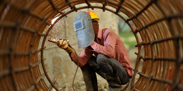 KRISHNA CHAUDHARY, 29yrs old migrated from sunsari, welding iron pillar for on-going Bridge expansion work supported by China AID at Kalanki, Kathmandu, Nepal on Monday, July 17, 2017. The workers used to earn daily wage of NRs. 800 (US$ 8) per day. (Photo by Narayan Maharjan/NurPhoto via Getty Images)