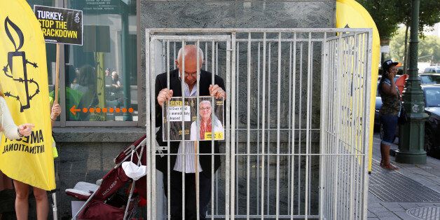 Amnesty International Belgium's Director Philippe Hensmans poses in a cage in front of the Turkish embassy in Brussels to protest against the detention of his Turkish counterpart Idil Eser, Belgium, July 10, 2017. REUTERS/Francois Lenoir TPX IMAGES OF THE DAY
