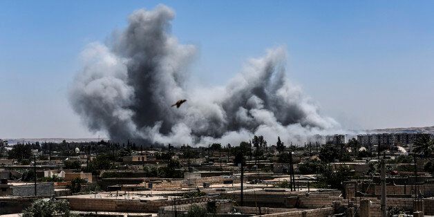 TOPSHOT - Smoke billows following an airstrike on the western frontline of Raqa on July 15, 2017, during an offensive by the Syrian Democratic Forces (SDF), an alliance of Kurdish and Arab fighters, to retake the city from Islamic State (IS) group fighters.The US-backed coalition has captured around 30 percent of Raqa city since it entered the IS bastion in June after a months-long operation to capture territory in the surrounding province. / AFP PHOTO / BULENT KILIC (Photo credit should read BULENT KILIC/AFP/Getty Images)