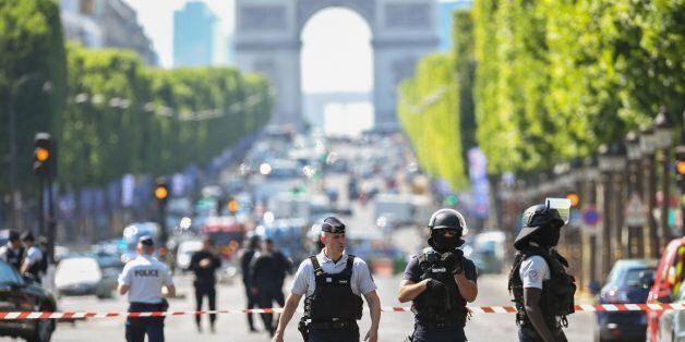 TOPSHOT - Police officers and anti-riot police officers patrol the Champs-Elysees avenue on June 19, 2017 on the Champs-Elysees avenue in Paris, after a car crashed into a police van before bursting into flames, with the driver being armed, probe sources said.A source close to the investigation said the driver was 'seriously injured'. / AFP PHOTO / ALAIN JOCARD (Photo credit should read ALAIN JOCARD/AFP/Getty Images)