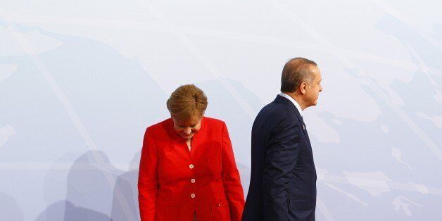 HAMBURG, GERMANY - JULY 07: German Chancellor Angela Merkel (L) welcomes Turkish President Recep Tayyip Erdogan (R) for a family photo taking during G20 (Group of 20) leaders' summit in Hamburg, Germany on July 7, 2017. Germany is hosting leaders from the worlds 20 largest economies at the Hamburg summit on July 7-8, set to focus on the global economy, trade, climate change, and the fight against international terrorism. (Photo by Michele Tantussi/Anadolu Agency/Getty Images)