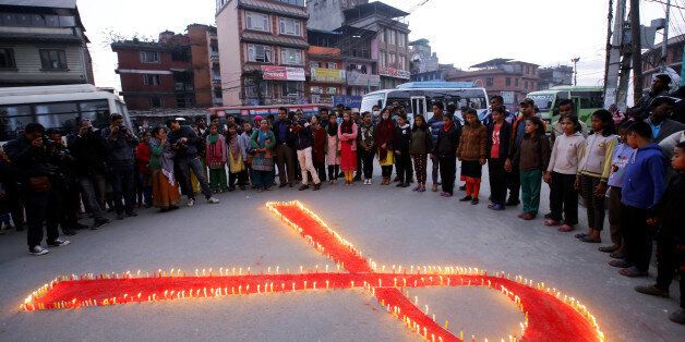 People gather around lit candles in the shape of a ribbon during a HIV/AIDS awareness campaign ahead of World Aids Day, in Kathmandu, Nepal November 30, 2016. REUTERS/Navesh Chitrakar