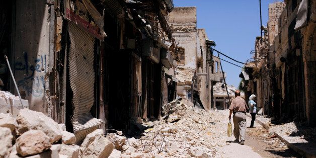 A man walks past damaged houses in the old city of Aleppo, Syria July 13, 2017. REUTERS/Omar Sanadiki