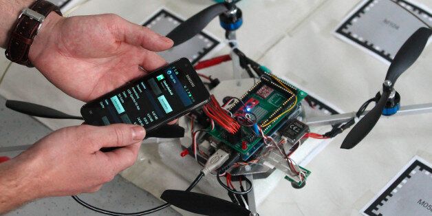 A student of the Virtual-Reality-Team at Vienna University of Technology checks a smartphone before attaching it to a quadcopter in Vienna September 5, 2013. The quadcopter, which was developed by students and scientists of the university, can negotiate its way through a room completely on its own with all the necessary computing power done by an on-board standard smartphone. Picture taken September 5, 2013. REUTERS/Heinz-Peter Bader (AUSTRIA - Tags: SCIENCE TECHNOLOGY)