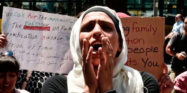 A Syrian woman shouts outside the German embassy in Athens on July 19, 2017 during a protest against delays in the family reunification process in Germany. The German government has significantly cut back on family reunions for refugees arriving from Greece since May 2017. Asylum seekers - mostly Syrian refugees in Greece's case - are entitled to join family members elsewhere in the European Union within six months from the date their request is approved. / AFP PHOTO / LOUISA GOULIAMAKI (Photo credit should read LOUISA GOULIAMAKI/AFP/Getty Images)