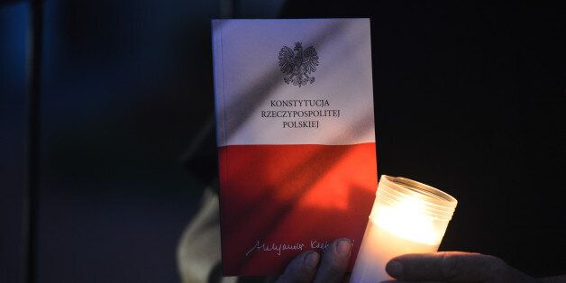 A person holds a copy of Polish Constitution during an anti-government protest - a candle-lit vigil in front of Rzeszow's District Court, on Sunday evening in solidarity with other Polish towns, demanding for Polish President veto the proposed judical reform.On Sunday, July 23, 2017, in Rzeszow, Poland. (Photo by Artur Widak/NurPhoto via Getty Images)