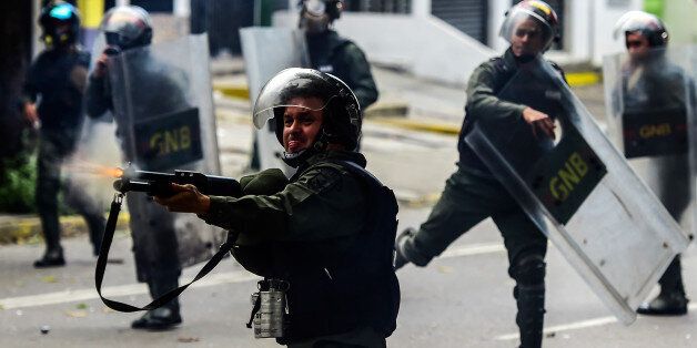 Bolivarian National Guard members clash with demonstrators during an anti-government protest in Caracas, on July 20, 2017. A 24-hour nationwide strike got underway in Venezuela Thursday, in a bid by the opposition to increase pressure on beleaguered leftist President Nicolas Maduro following four months of deadly street demonstrations. / AFP PHOTO / RONALDO SCHEMIDT (Photo credit should read RONALDO SCHEMIDT/AFP/Getty Images)
