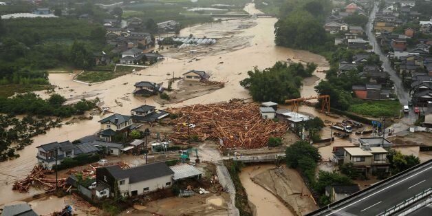 The picture shows an areal view of flooded Asakura City, Fukuoka prefecture, on July 6, 2017.One person reportedly died and at least 18 are missing, after huge floods swept away houses in southern Japan, tearing up roads as they surged through villages, with authorities warning hundreds of thousands of people to flee. JAPAN OUT / AFP PHOTO / JIJI PRESS AND AFP PHOTO / STR / Japan OUT (Photo credit should read STR/AFP/Getty Images)