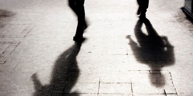 Shadow of two person on pattered sidewalk in black and white