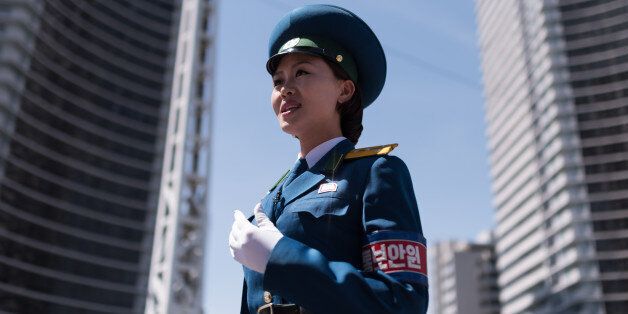 TOPSHOT - In a photo taken on June 5, 2017 a traffic security officer stands on duty at an intersection in Pyongyang. Officially known as traffic security officers but universally referred to as traffic ladies, they are chosen for their looks in a society that remains traditionalist in many respects. They must leave the role if they marry, and have a finite shelf-life, with compulsory retirement looming at just 26. The 300-odd ladies are unique to Pyongyang, which North Korean authorities are always keen to present in the best possible light despite their nuclear-armed country's impoverished status, and ensure a steady supply of photogenic young women who are the favourite subject of visiting tourists and journalists. / AFP PHOTO / Ed JONES / To go with NKorea-transport-tourism-gender-police, FOCUS by Sebastien Berger (Photo credit should read ED JONES/AFP/Getty Images)