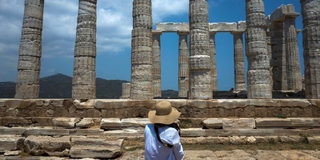 A tourist takes a picture of the temple of Poseidon at cape Sounion, 70 km soutHeast of Athens on June 5, 2017. / AFP PHOTO / Angelos Tzortzinis (Photo credit should read ANGELOS TZORTZINIS/AFP/Getty Images)