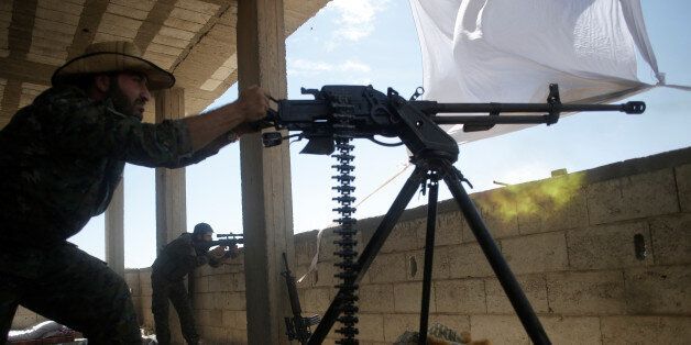 A Kurdish fighter from the People's Protection Units (YPG) fires heavy machine-gun at Islamic State militants in Raqqa, Syria June 21, 2017. REUTERS/Goran Tomasevic