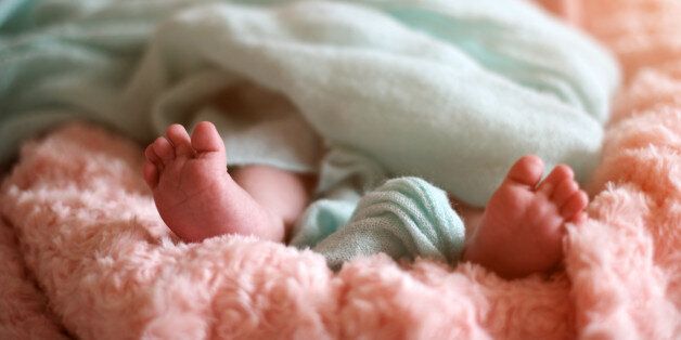 cute newborn baby feets in the bed