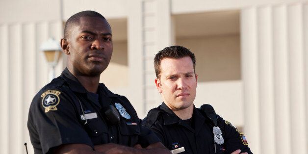 Multi-ethnic police officers (20s). Focus on Caucasian man.