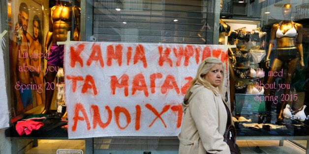 ERMOU STREET, ATHENS, ATTICA, GREECE - 2015/04/05: A woman walks past a closed shop in Ermou Street, which has a banner outside the door that reads 'No shop opening on Sundays'. Retail workers protested in Athens Ermou Street against the opening of shops on Sundays in Greece. The new government had announced that it will change the law, which currently allows shops to open on 7 Sundays in the year, but not acted on this yet. (Photo by Michael Debets/Pacific Press/LightRocket via Getty Images)