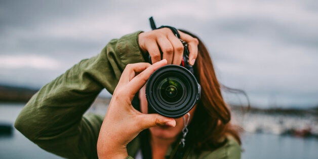 A young woman using a DSLR camera