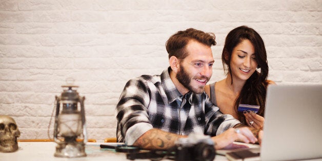 Young couple in love planning a trip with laptop