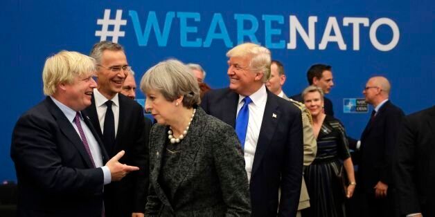 U.S. President Donald Trump (C) reacts while speaking to NATO Secretary General Jens Stoltenberg (2-L) and British Foreign Minister Boris Johnson (L) as Britain's Prime Minister Theresa May passes during a working dinner meeting at the NATO (North Atlantic Treaty Organization) headquarters in Brussels on May 25, 2017 during a NATO summit. / AFP PHOTO / POOL / Matt Dunham (Photo credit should read MATT DUNHAM/AFP/Getty Images)