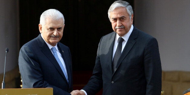 Turkish Prime Minister Binali Yildirim (L) and Turkish Cypriot leader Mustafa Akinci shake hands during a visit in Nicosia, northern Cyprus March 9, 2017. REUTERS/Yiannis Kourtoglou