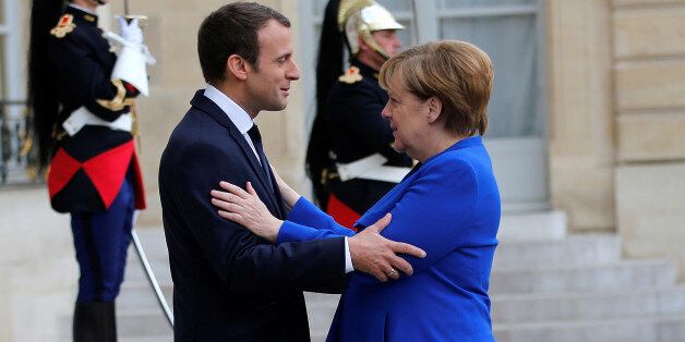 French President Emmanuel Macron welcomes German Chancellor Angela Merkel as she arrives to attend a Franco-German joint cabinet meeting at the Elysee Palace in Paris, France, July 13, 2017. REUTERS/Stephane Mahe TPX IMAGES OF THE DAY