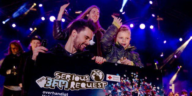 Dutch 3FM DJ's Domien Verschuuren (L) and Frank van der Lende show together with 6 year old Tijn Kolsteren the amount of money (8,744,131 euros) they have raised at the House of Glass (Het Glazen Huis) of Serious Request in Breda, on December 24, 2016. Serious Request is a annual project by Dutch radio station 3FM in which they collect money for projects of the Red Cross, this year to prevent children dying from pneumonia. During the project, three DJs live in a house of glass for six days without eating anything, instead drinking special juice to stay fit. Tijn is terminally ill (he suffers from brain cancer) and had one last wish. He wanted to raise as much money as possible to help other children. / AFP / ANP / Sander Koning / Netherlands OUT (Photo credit should read SANDER KONING/AFP/Getty Images)