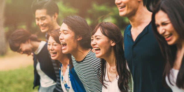 Big friend hug in the park. A lot of friends are posing for the photo in the park. They seems very happy.