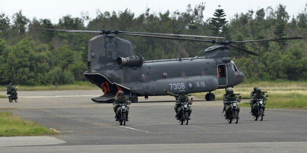 Armed Taiwanese soldiers ride on motorcycles next to a US-made CH-47 helicopter during the 'Han Kuang' (Han Glory) life-fire drill, some 7 kms (4 miles) from the city of Magong on the outlying Penghu islands on May 25, 2017.Taiwan forces conducted live-fire war games in its biggest annual military exercise on May 25, presided by President Tsai Ing-wen, as the island faces growing threat from its cross-strait rival China. / AFP PHOTO / SAM YEH (Photo credit should read SAM YEH/AFP/Getty Images)
