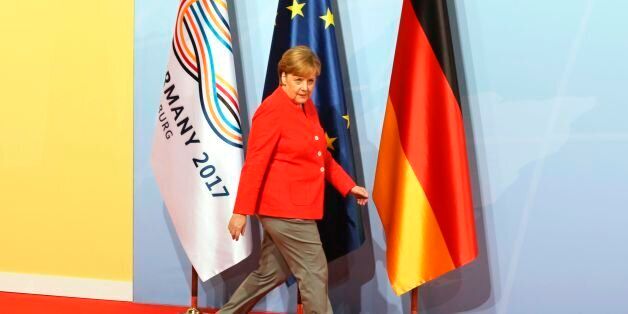 German Chancellor Angela Merkel walks past flags as she arrives before greeting heads of State at the start of the G20 meeting in Hamburg, northern Germany, on July 7.Leaders of the world's top economies will gather from July 7 to 8, 2017 in Germany for likely the stormiest G20 summit in years, with disagreements ranging from wars to climate change and global trade. / AFP PHOTO / AFP PHOTO AND POOL / LUDOVIC MARIN / SOLELY FOR REUTERS (Photo credit should read LUDOVIC MARIN/AFP/Getty Images)