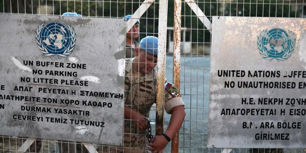 A U.N. soldier locks a gate inside the UN-controlled buffer zone in Nicosia, Cyprus June 28, 2017. REUTERS/Yiannis Kourtoglou
