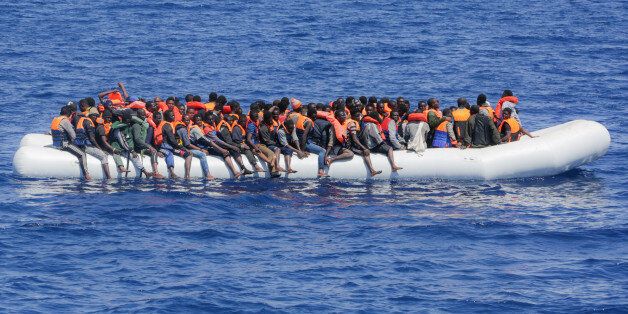LAMPEDUSA, ITALY - MAY 19: Refugees and migrants are seen floating in an overcrowded rubber boat as they wait to be assisted by search and rescue crew members from NGO Sea-Eye on May 18, 2017 in international waters off the coast of Libya. (Photo by Christian Marquardt/NurPhoto via Getty Images)