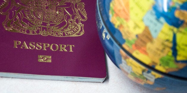 The bottom half of a British passport, next to a globe.